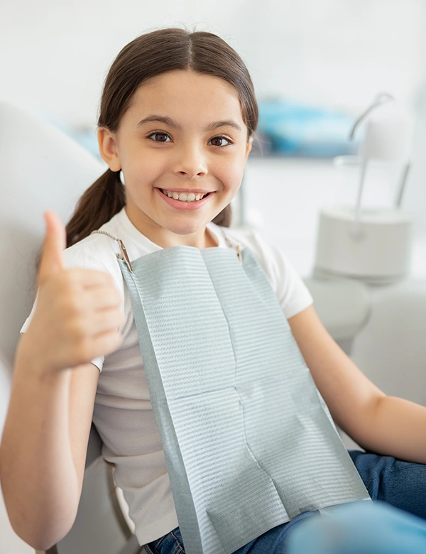 Child Smiling With Thumbs Up