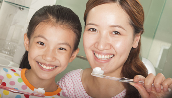 mother and daughter brushing teeth